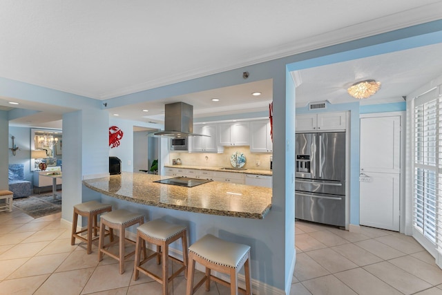 kitchen with island exhaust hood, dark stone counters, white cabinets, backsplash, and stainless steel refrigerator with ice dispenser