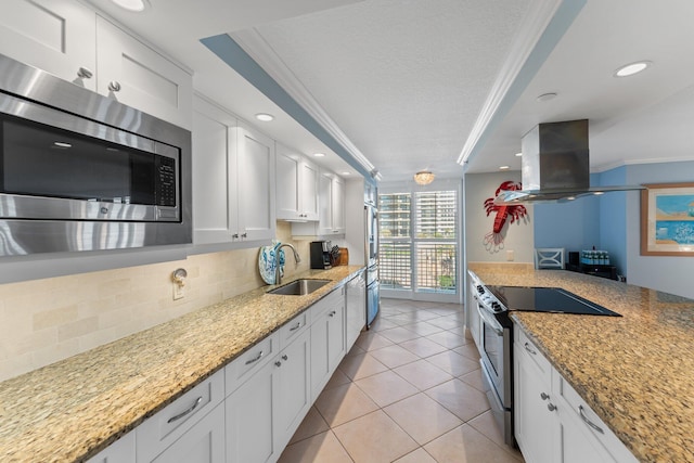 kitchen with ornamental molding, white cabinets, stainless steel appliances, and island exhaust hood