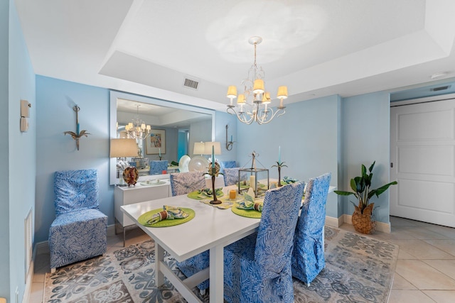 tiled dining space with a raised ceiling and a notable chandelier