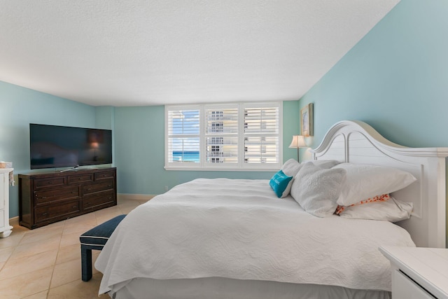 bedroom with a textured ceiling and light tile flooring