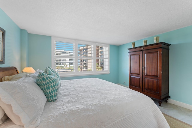 bedroom with light tile floors and a textured ceiling