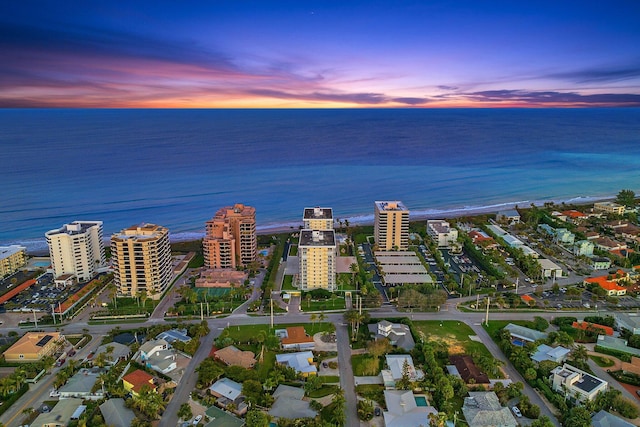 aerial view at dusk featuring a water view