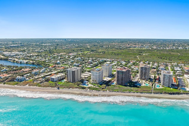 birds eye view of property with a water view and a beach view