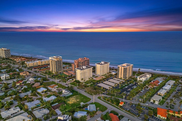 aerial view at dusk featuring a water view