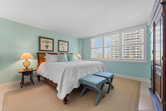 bedroom with light tile floors and a textured ceiling