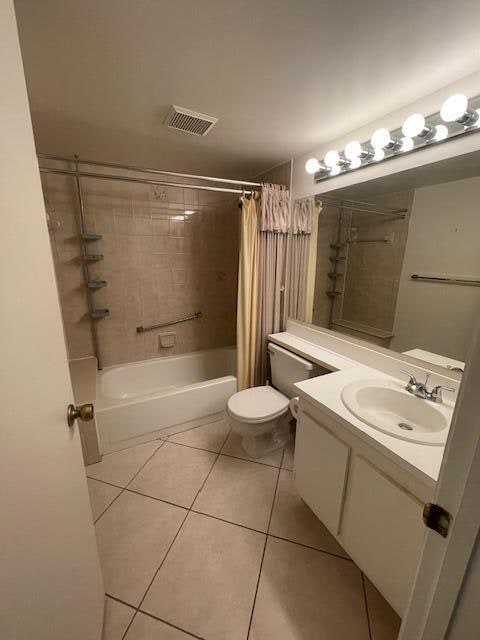 full bathroom featuring tile patterned floors, vanity, shower / bathtub combination with curtain, and toilet