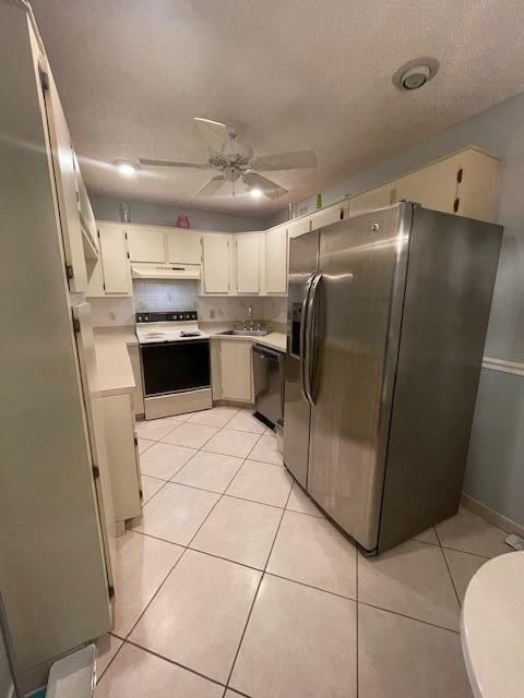 kitchen featuring ceiling fan, dishwashing machine, stainless steel refrigerator with ice dispenser, light tile patterned flooring, and range with electric stovetop