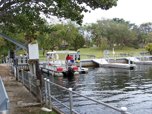 dock area with a water view and a yard