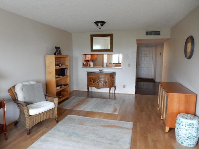 sitting room with a textured ceiling and hardwood / wood-style flooring