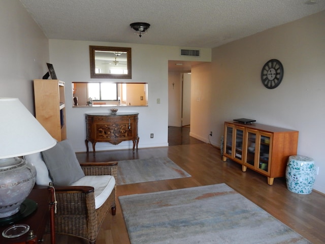 living room with dark hardwood / wood-style floors and a textured ceiling