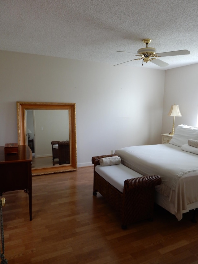 bedroom featuring a textured ceiling, ceiling fan, and dark hardwood / wood-style floors