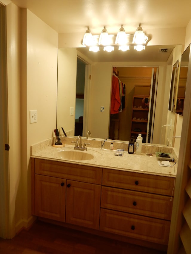 bathroom with vanity with extensive cabinet space and hardwood / wood-style floors