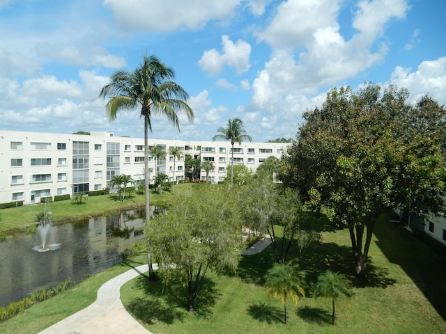 view of property's community featuring a lawn and a water view