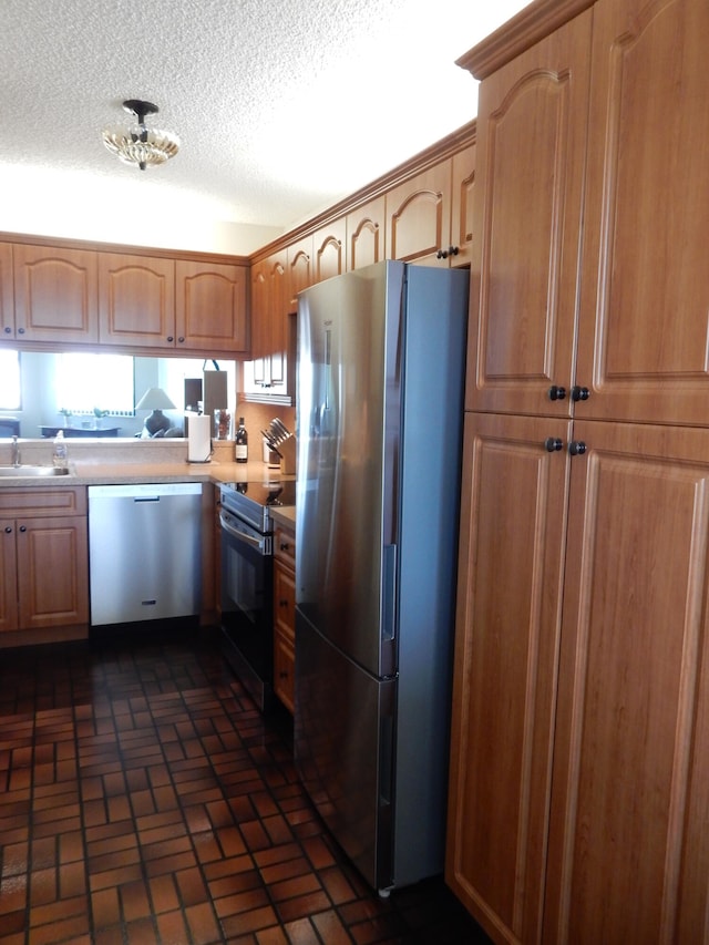 kitchen featuring appliances with stainless steel finishes, a textured ceiling, and sink