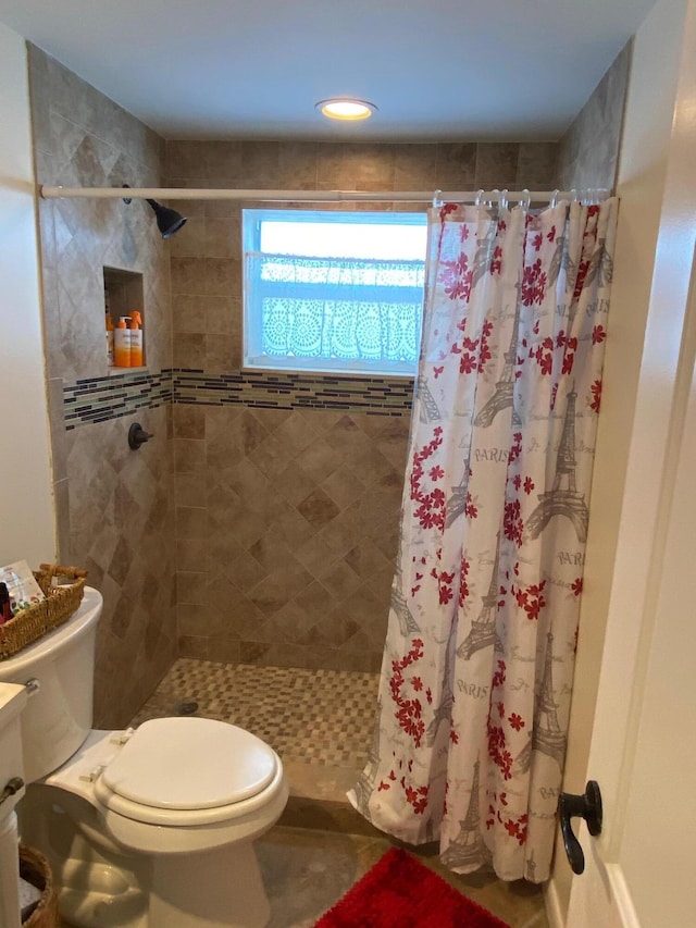 bathroom featuring walk in shower and toilet