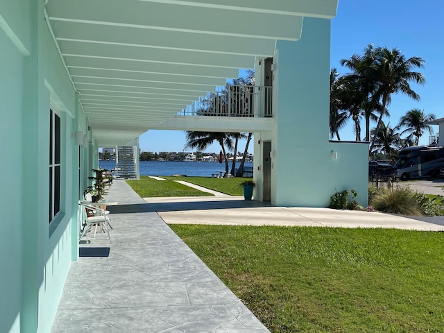 view of yard with a water view and a patio