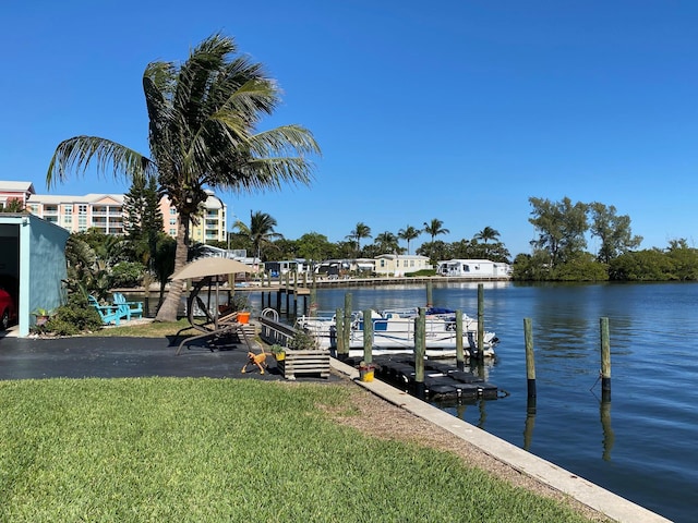 dock area featuring a water view and a lawn