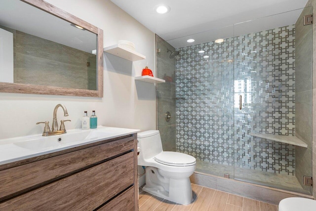 bathroom featuring an enclosed shower, toilet, and vanity