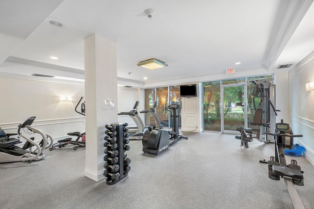 exercise room featuring a raised ceiling and crown molding