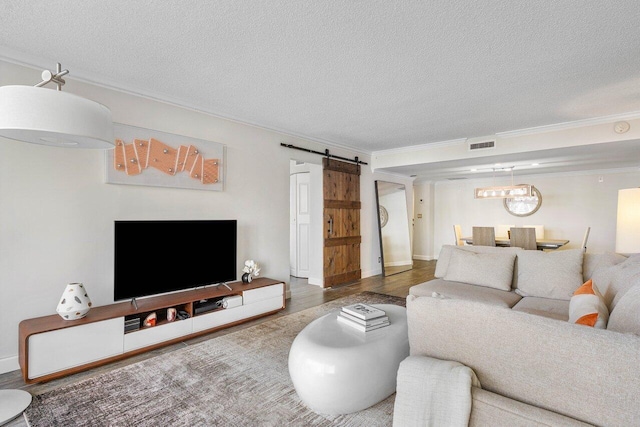 living room with a barn door, a textured ceiling, and dark hardwood / wood-style flooring