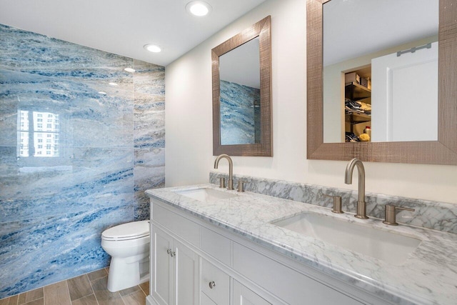 bathroom with toilet and double sink vanity