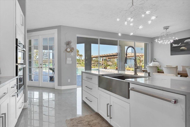 kitchen featuring french doors, pendant lighting, light tile floors, white cabinets, and a notable chandelier