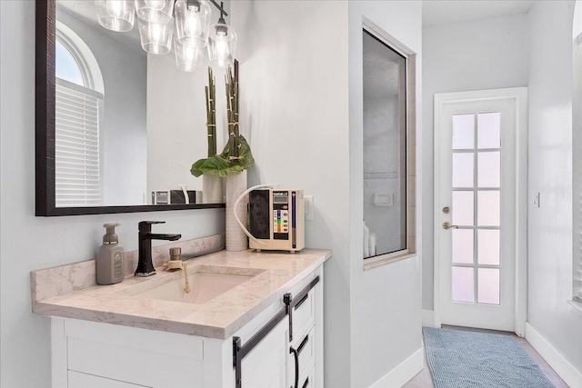 bathroom featuring a notable chandelier and vanity