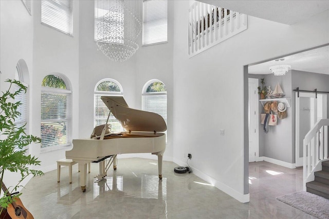 interior space featuring a barn door, a high ceiling, light tile floors, and an inviting chandelier