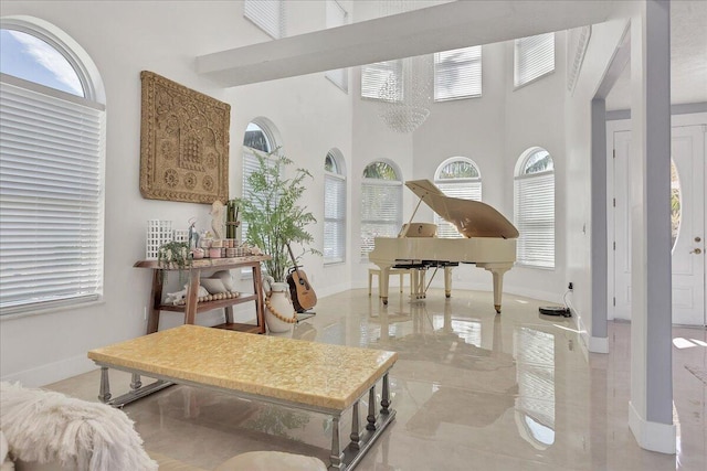 sitting room with a high ceiling, a notable chandelier, and light tile floors