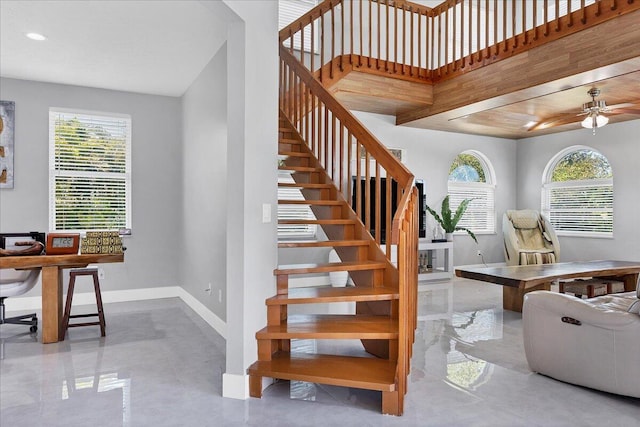 stairs featuring ceiling fan