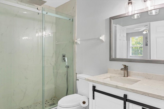 bathroom featuring toilet, a shower with door, ceiling fan, and large vanity