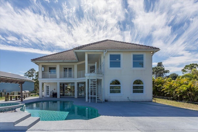 back of house featuring a balcony and a patio