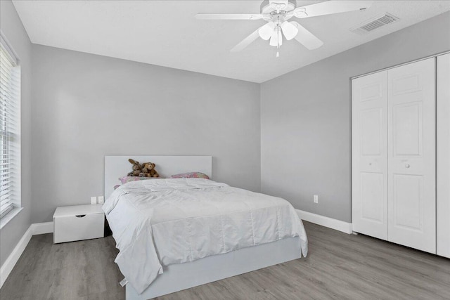 bedroom featuring a closet, ceiling fan, and dark hardwood / wood-style flooring