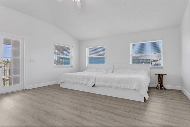 bedroom with lofted ceiling, multiple windows, ceiling fan, and light hardwood / wood-style flooring