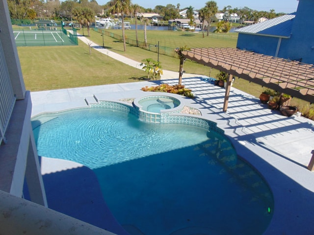 view of pool featuring an in ground hot tub and a lawn