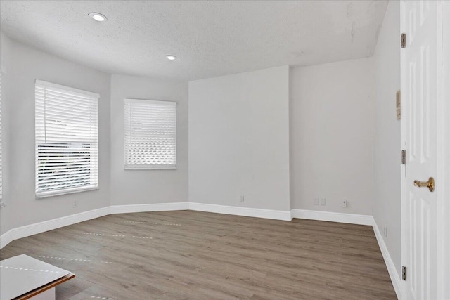 unfurnished room featuring a textured ceiling and dark hardwood / wood-style floors