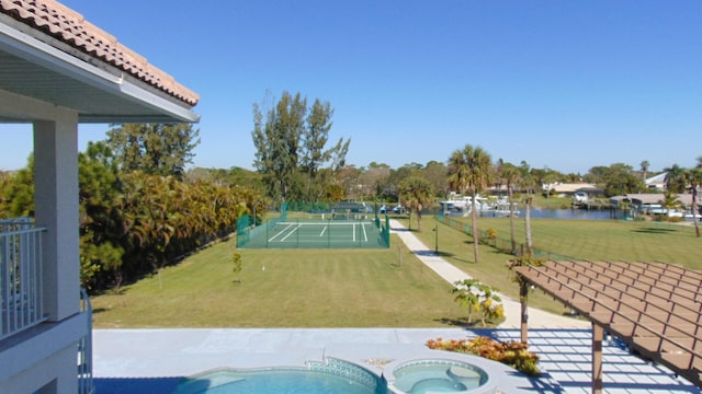 view of yard with tennis court and a water view