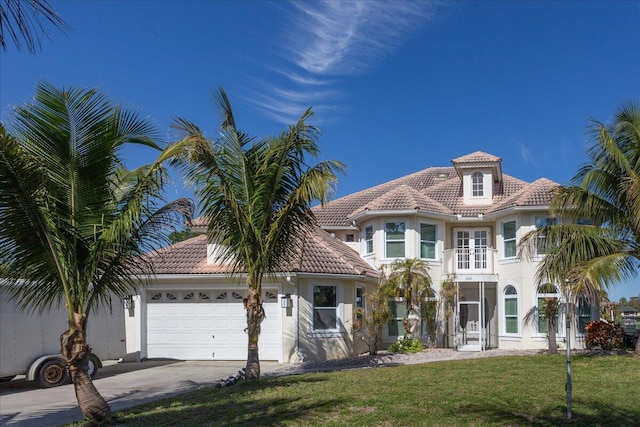 mediterranean / spanish house with a front yard and a garage