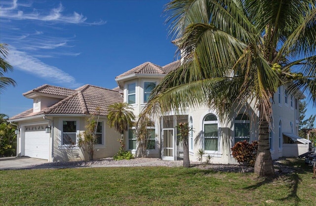 mediterranean / spanish-style house featuring a front lawn and a garage