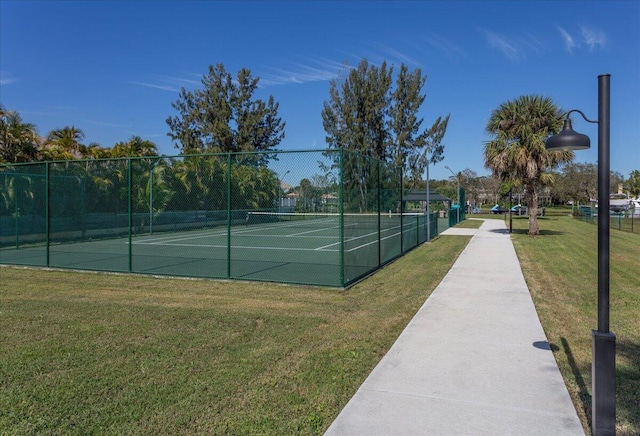 view of tennis court featuring a yard