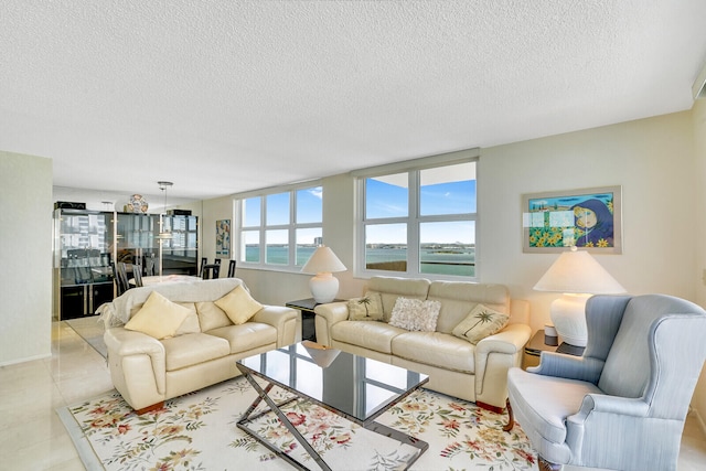 tiled living room featuring a water view and a textured ceiling