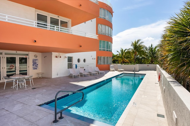 view of pool featuring french doors and a patio