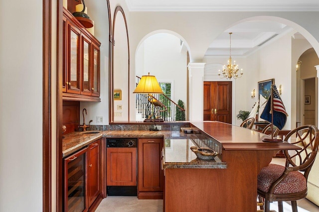 kitchen featuring sink, beverage cooler, a chandelier, a breakfast bar area, and pendant lighting