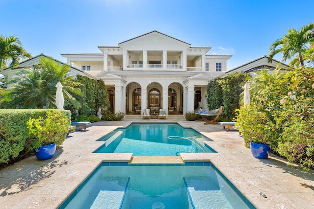 rear view of house featuring a balcony and a patio