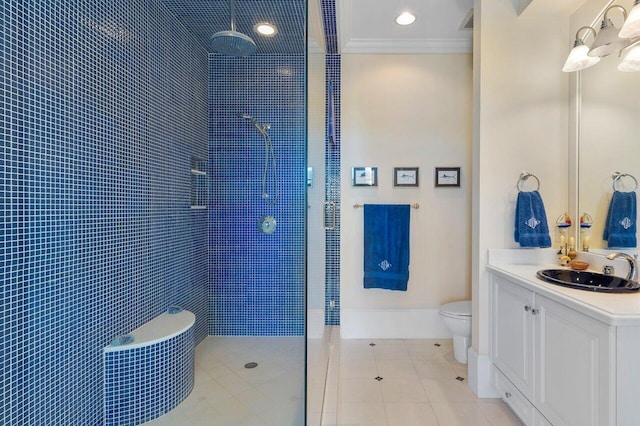 bathroom with toilet, vanity, ornamental molding, tile floors, and a tile shower