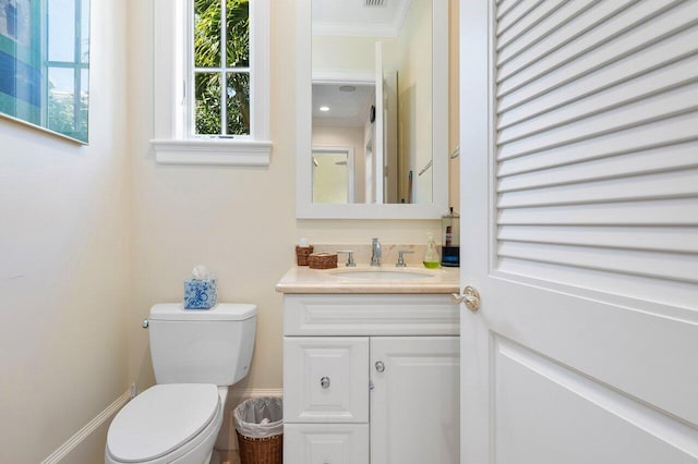 bathroom with toilet, ornamental molding, and vanity with extensive cabinet space