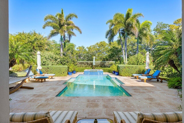 view of pool featuring a patio and an in ground hot tub