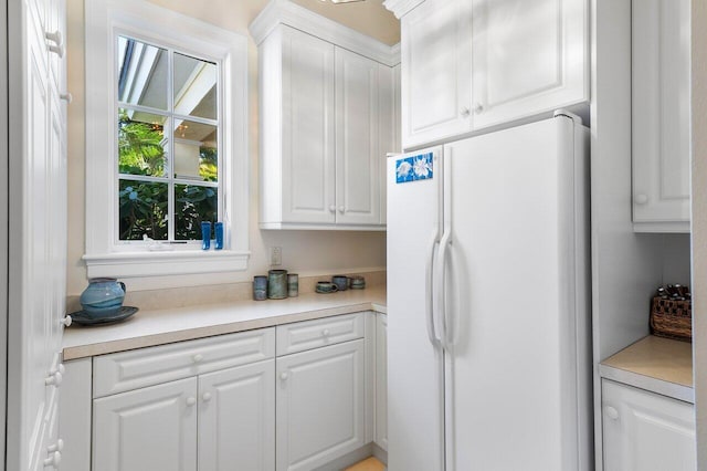 kitchen with white refrigerator and white cabinetry