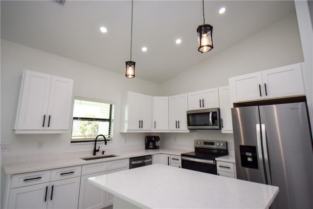 kitchen with appliances with stainless steel finishes, sink, pendant lighting, and lofted ceiling