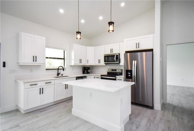 kitchen featuring a center island, white cabinetry, appliances with stainless steel finishes, and light hardwood / wood-style floors